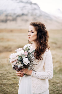 Beautiful woman standing by flowering plant