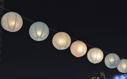 Low angle view of illuminated lights against sky at night