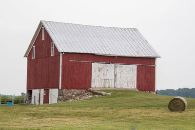 Barn on field against sky