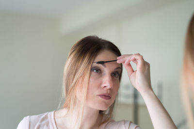Woman applying make-up at home