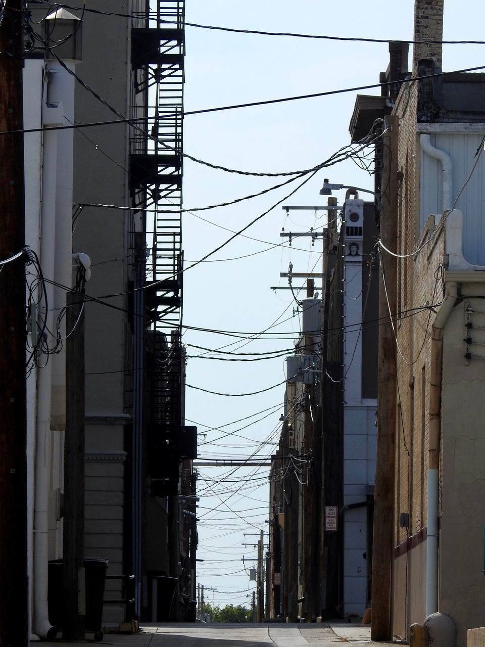 LOW ANGLE VIEW OF ELECTRICITY PYLON BY POLE AGAINST SKY