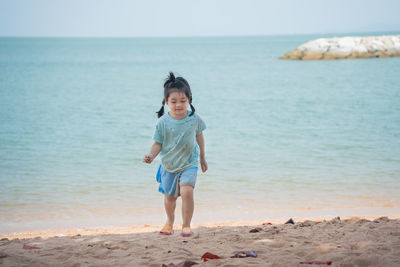 Portrait of young woman standing at beach