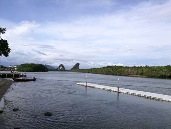 Bridge over river against cloudy sky