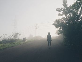 Rear view of man on road against sky