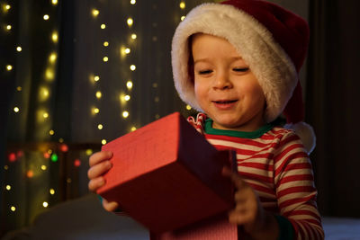 Christmas boy in santa hat smiling at home evening. new year and holidays. christmas happiness. the