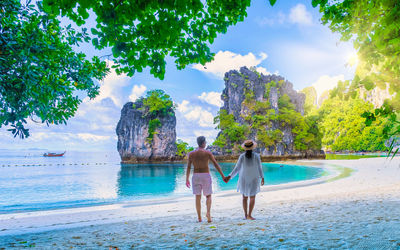 Rear view of woman standing at beach