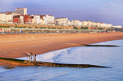 Buildings by sea against sky in city