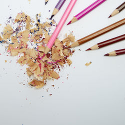 High angle view of multi colored pencils on white background