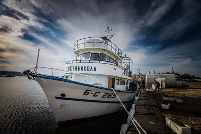 Boats moored at harbor against sky