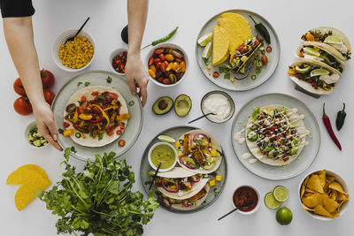 Person preparing healthy feast with various mexican food