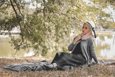 Portrait of young woman sitting on field