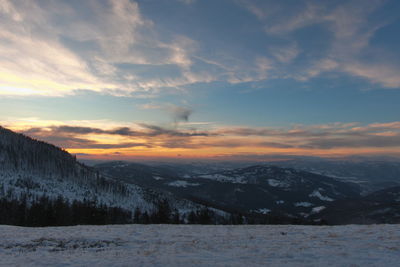 Scenic view of snowcapped mountains against sky during sunset