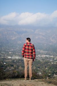 Rear view of man standing against mountain