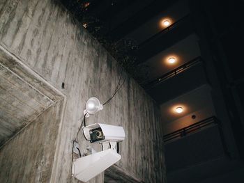 Low angle view of illuminated lighting equipment against sky