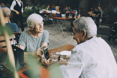 Rear view of people sitting on table