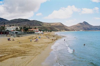 People on beach against sky