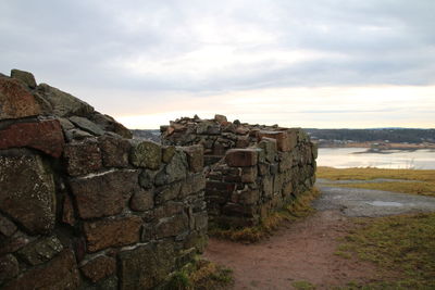 Stack of stone wall against sky