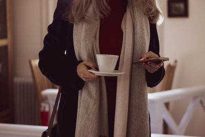 Midsection of woman holding coffee cup