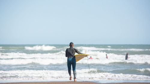 Full length of man standing on beach against clear sky