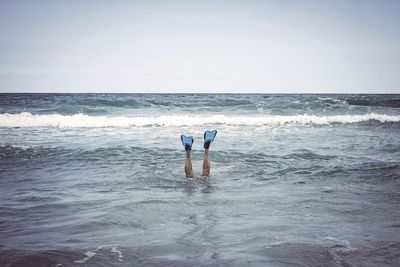 Low section of person swimming in sea