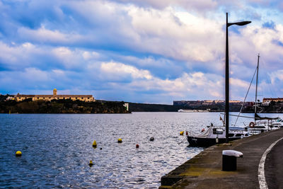 Sailboats moored on river against sky