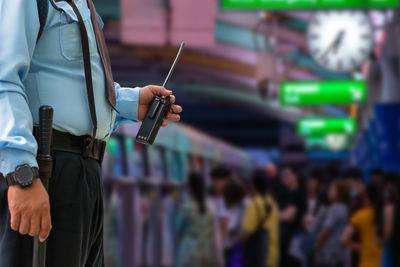 Midsection of man holding camera