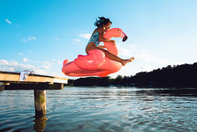 Full length of woman jumping in lake