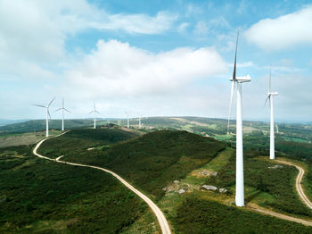 Wind turbines on land against sky