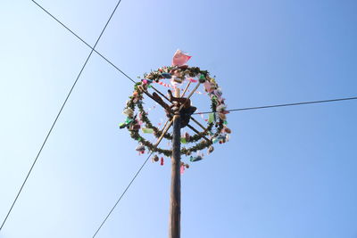 Low angle view of telephone pole against clear blue sky