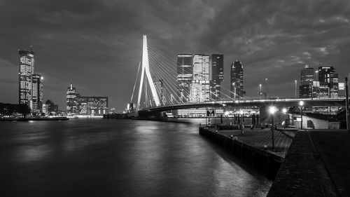 Bridge over river against cloudy sky