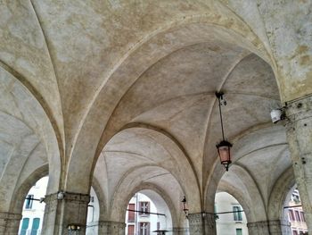 Low angle view of old lamp hanging from historic building ceiling