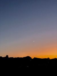 Silhouette landscape against clear sky during sunset