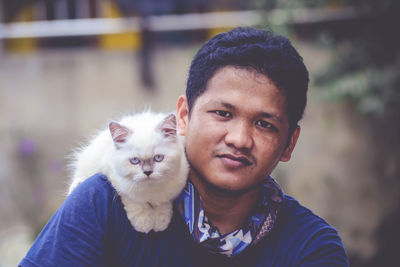 Portrait of young man with cat