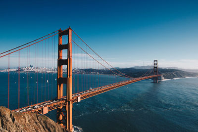 View of suspension bridge against blue sky