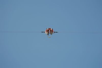 Low angle view of helicopter against clear sky