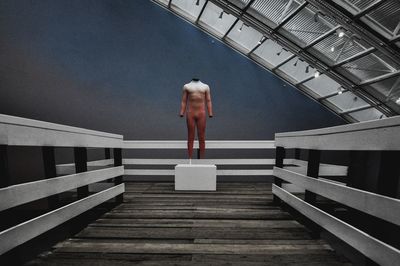 Digital composite image of person standing on pier
