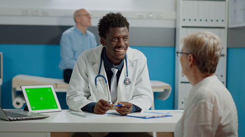 Smiling doctor talking to patient at hospital