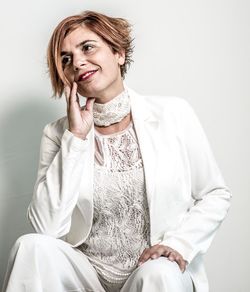 Portrait of smiling young woman sitting against wall