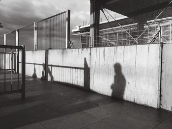 Shadow of man on surrounding wall against building