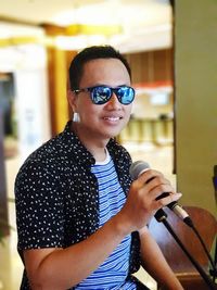 Portrait of smiling young man holding camera