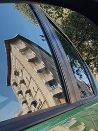 Low angle view of building seen through car window