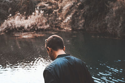 Rear view portrait of young man in lake