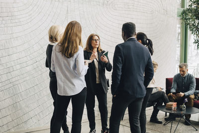 Mature businesswomen discussing with coworkers in meeting at office