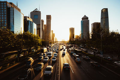 Traffic on city street amidst buildings against sky