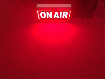 Low angle view of illuminated sign on wall