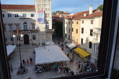 High angel view of people on street seen through window