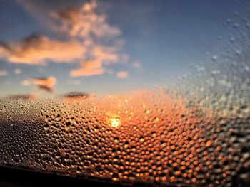Close-up of wet sand against sky during sunset