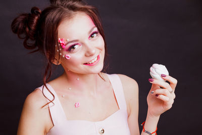 Close-up of young woman against gray background