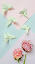 Close-up of roses and butterfly origami on table