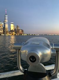 Close-up of coin-operated binoculars against cityscape